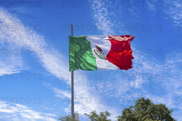Los Cabos, Mexico, Mexican tricolor national striped flag proudly waving at mast in the air with