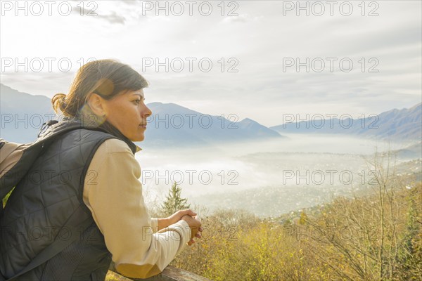 Woman Enjoy Panoramic View over Mountain Scape with a Foggy Valley in Locarno, Ticino, Switzerland,