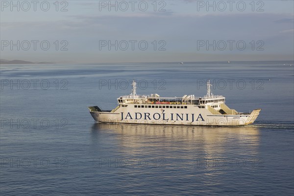 White and blue Jadrolinija Jadran Rijeka ferry boat on calm Adriatic sea leaving Port of Zadar in