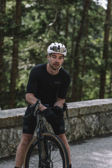 Road bike rider in spring in the Allgäu against the picturesque backdrop of the Alps, Bavaria,