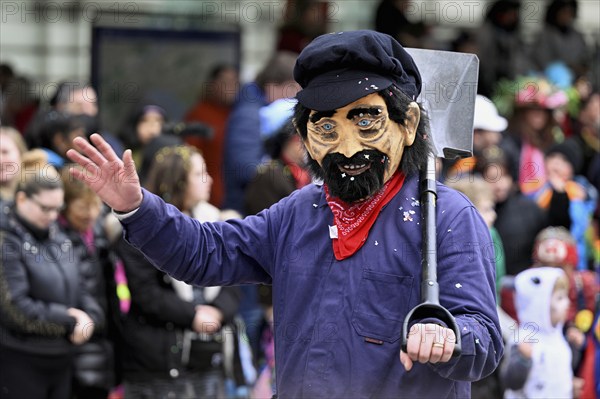 Person masked as farmer, field worker at the carnival parade of the Wey guild on Rose Monday,