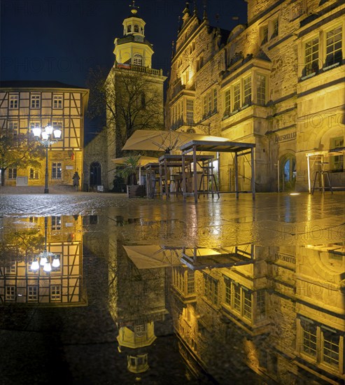 Town hall and church Marketplace illuminated Reflection in puddle Panorama Rinteln Germany