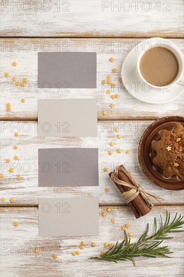 Gray paper business card mockup with cup of coffee and cake on white wooden background. Blank, top