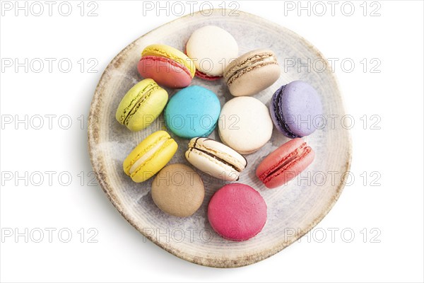 Multicolored macaroons on ceramic plate isolated on white background. top view, still life, flat
