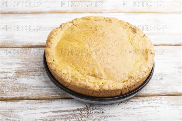 Autumn onion pie and cup of coffee on white wooden background. Side view, close up