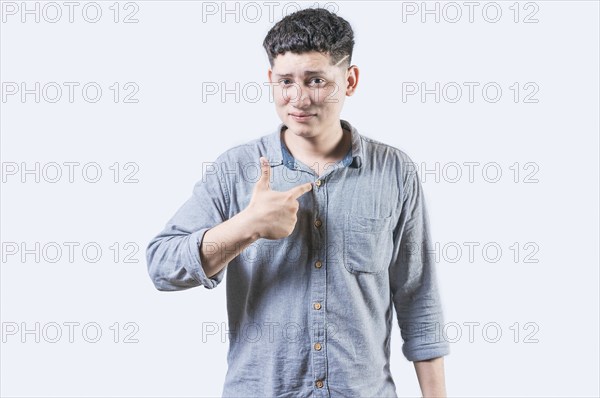 Embarrassed young man pointing at himself isolated. Confused man pointing at himself isolated