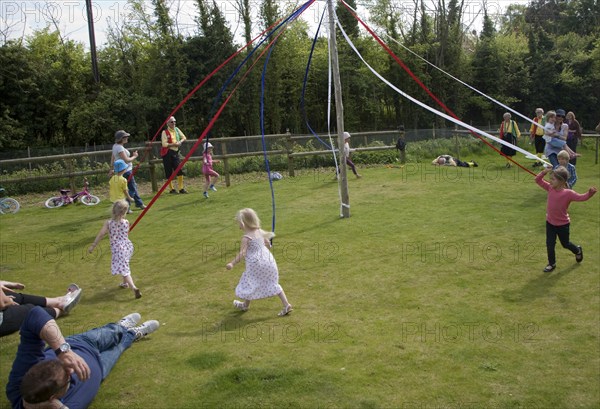 Children dance around a maypole at an English country festival, Shottisham, Suffolk, England,