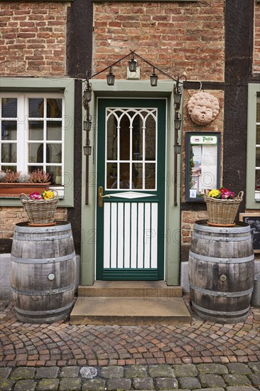 Entrance area of a restaurant in a historic half-timbered brick house with entrance door, white