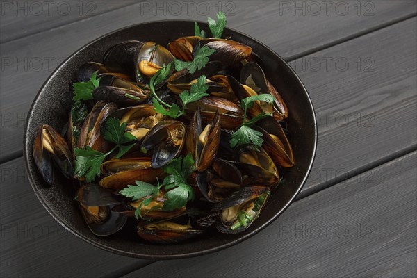 Fresh, Boiled mussels, Black Sea, with parsley and lemon, on a wooden table, no people