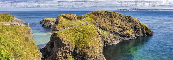 Cliff landscape with bridge and turquoise water under a blue sky, Carrick Bridge