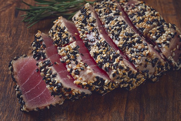 Fillet of red tuna meat, fried in sesame seeds, homemade, close-up, no people, on a wooden