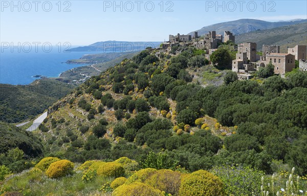 Historic stone houses of a village overlooking the coast under a clear sky, residential towers,