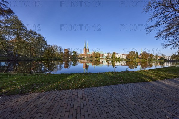 Long shot of the mill pond, park, trees, Lübeck Cathedral, symmetrical reflections on the water