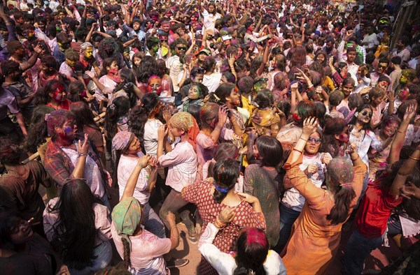 Revellers dancing in the beat of music as they celebrate Holi on a street, the Hindu spring