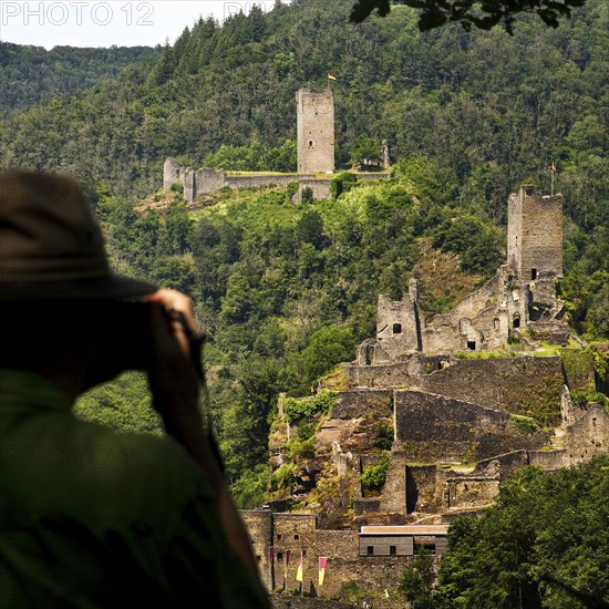 A man photographs the two castles, Oberburg and Niederburg of Manderscheid, South Eifel, Eifel,