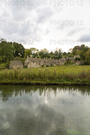 Famous Cotswold buildings at Arlington Row viewed from River Colne, Bibury, Gloucestershire,