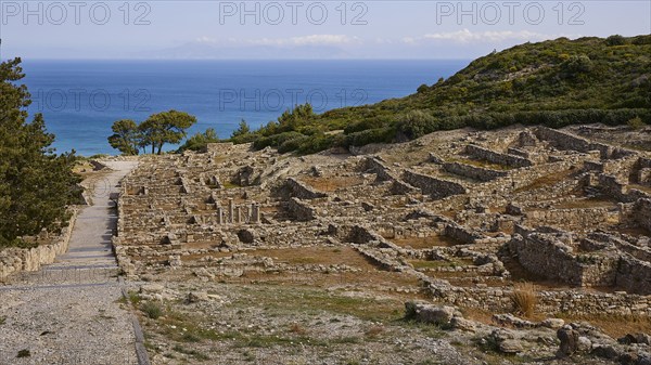 Ancient ruins on a hill with a view of the sea and a path in the foreground, Hellenistic houses,