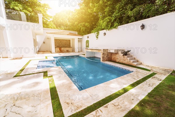 Homemade swimming pool surrounded by trees. Beautiful crystal clear swimming pool in a backyard.