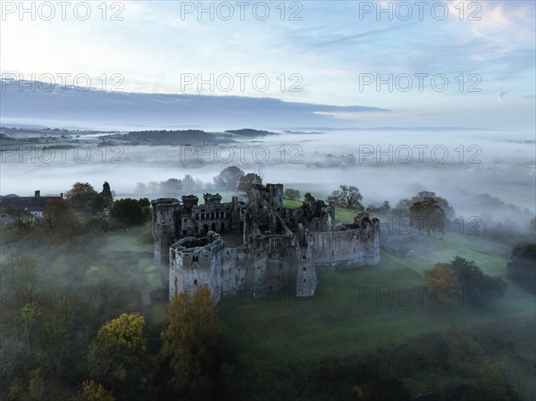 Raglan Castle in the fog at dawn from a drone, Monmouthshire, Wales, England, United Kingdom,