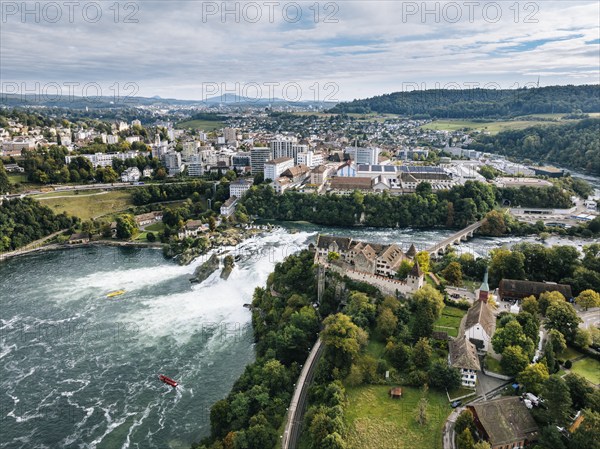 Aerial view of the Rhine Falls with Laufen Castle with autumnal vegetation, on the horizon the town