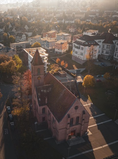 Church in urban surroundings in autumn weather and oblique sunlight, Nagold, Black Forest, Germany,