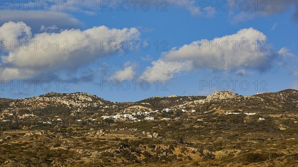 View of a hilly landscape with grassy hills under a blue sky with white clouds, West Coast,
