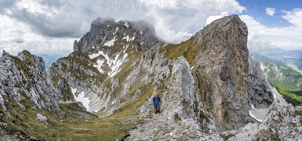 Mountaineers on a narrow hiking trail on a rocky ridge, ascent to the Maukspitze, clouds moving