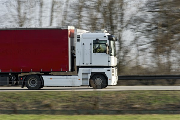 Unconcentrated driver in truck, lorry, articulated lorry driving fast on the A92 motorway, Renault