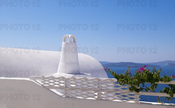 White building with traditional architecture in front of the blue sea and sky, surrounded by