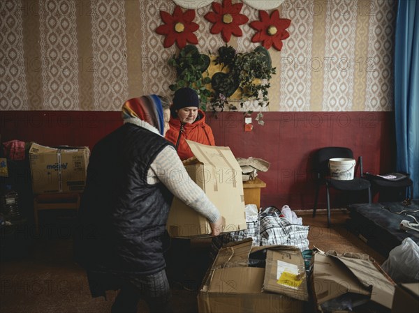 Two woman unload a delivery of relief supplies from the NGO Unbreakable Kharkiv at the village