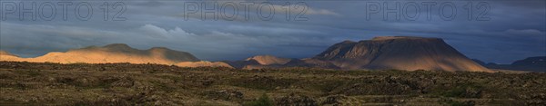 Large lava field and volcanic crater in the midnight sun, clouds, mood, panorama, Burfellshraun,
