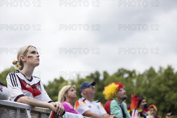 A woman watches the football match in the fan zone at the Brandenburg Tor during the quarter-final