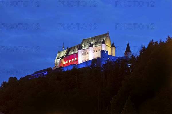 Vianden Castle, hilltop castle illuminated in the colours of the Luxembourg flag for the bank