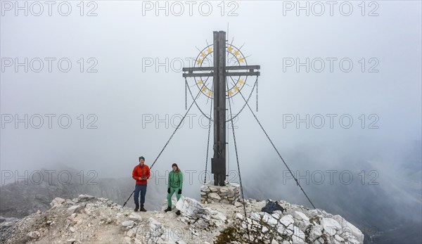Mountaineer on the summit of the Großer Kinigat with summit cross, Carnic Main Ridge, Carnic High
