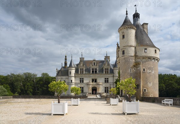 Imposing castle with ornamental towers and white tubs on a gravel path, Chenonceau Castle, Château