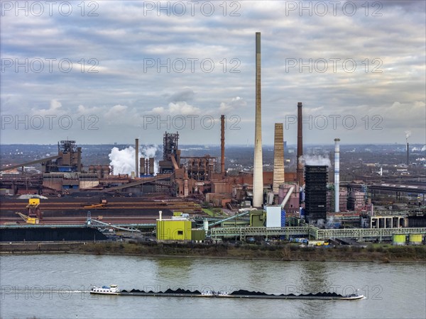 Industrial backdrop of the ThyssenKrupp Steel steelworks in Duisburg-Bruckhausen, cargo ship, coal