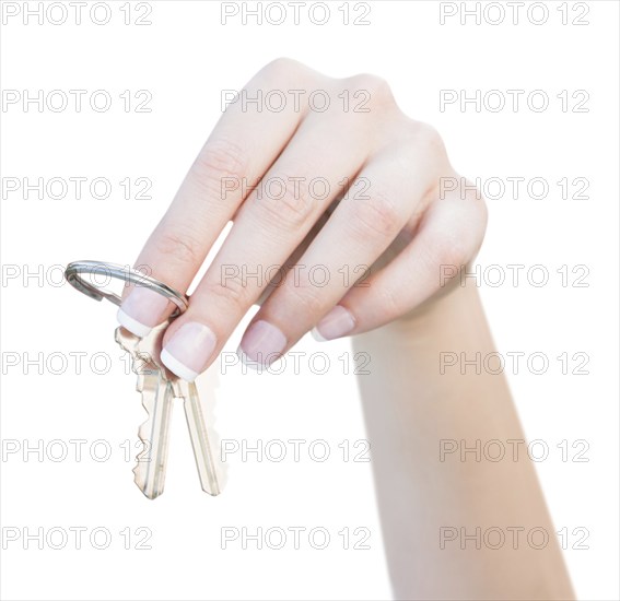 Female hand holding new house keys isolated on a white background