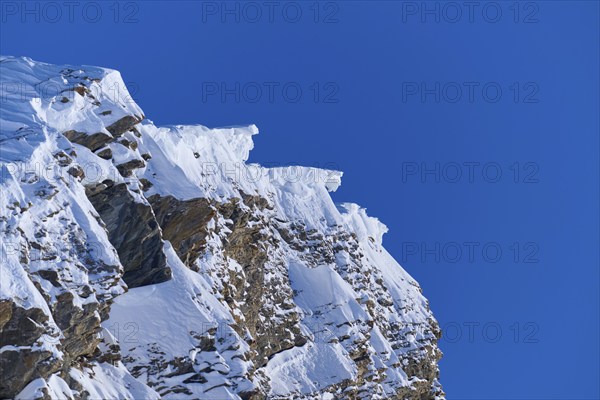 Snow-covered mountain peak with snow cornices under a clear blue sky, Gemmi Pass, Plattenhörner,