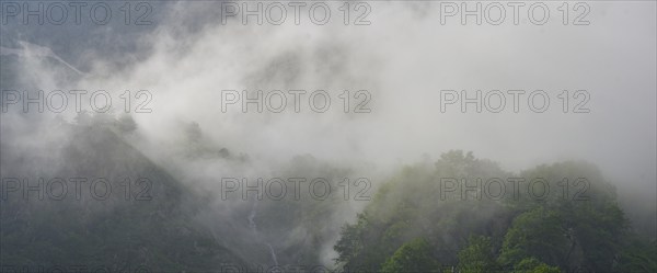 Clouds move over the mountains after a rain shower at Lago della Rovina, Entracque, province of