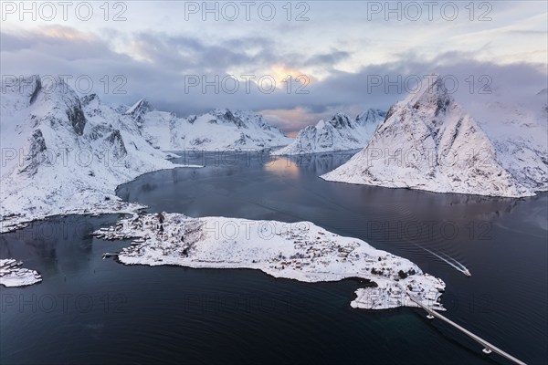 View of snow-covered islands, fjord and mountains, fishing village of Reine, Reinefjord, Lofoten,