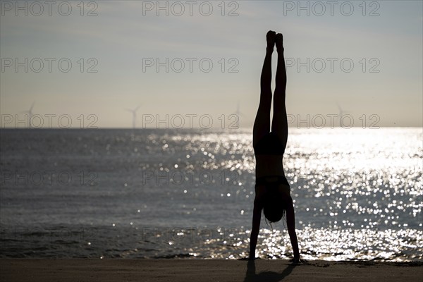Girl doing a handstand by the sea, Silhouette, Søndervig Strand, North Sea, Denmark, Europe