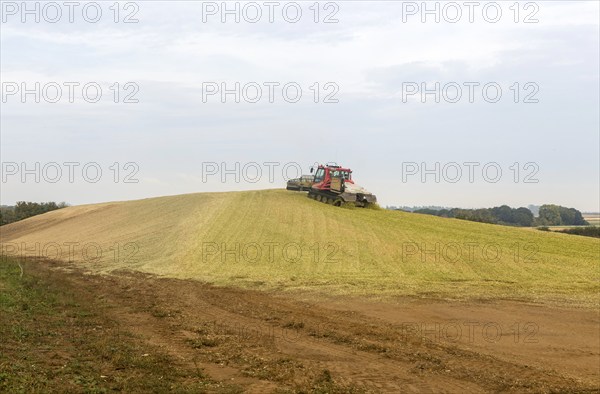 Piston Bully tracked bulldozer vehicle building silage clamp of sweetcorn maize in field stored for