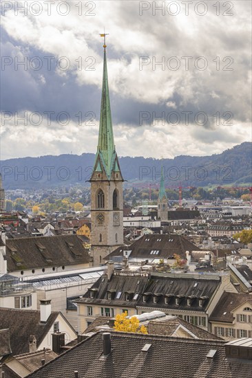 Close-up of a church tower with city and hills in a cloudy sky, Zurich, Switzerland, Europe