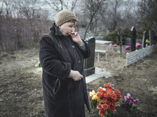 Ludmilla (68) mourns her grandson, who died at the front a month earlier, at the cemetery. The