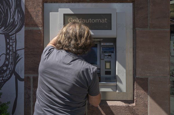 Man withdrawing money from an ATM, Nuremberg, Middle Franconia, Nuremberg, Germany, Europe