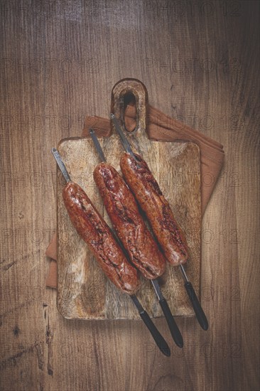 Fried sausages, in English with bacon, for grilling, on a cutting board, top view, no people