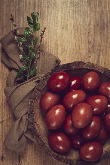Painted eggs in a wooden bowl, red, painted madder dye, powder from the roots of endro, with onion