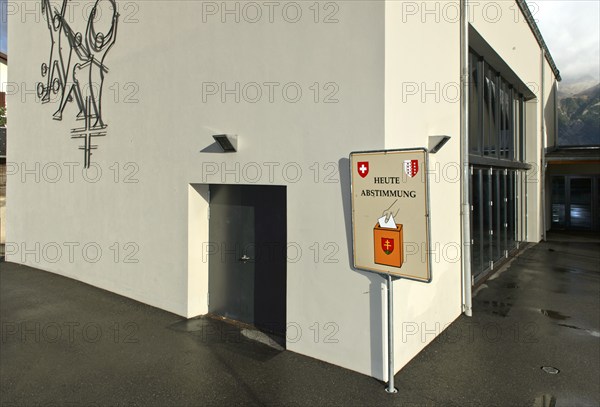 Sign inviting people to participate in referendums in front of the polling station, Unterbäch,