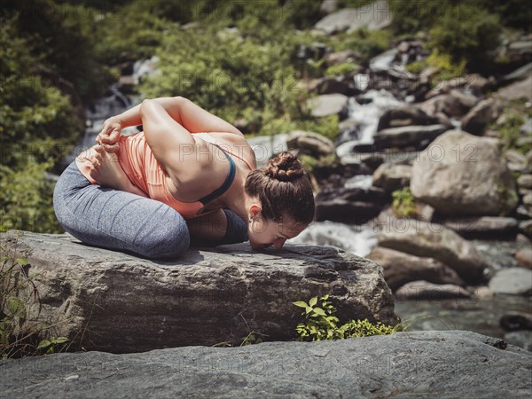 Vintage retro effect filtered hipster style image of Young sporty fit woman doing yoga, meditating