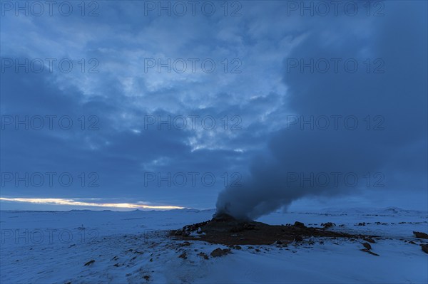 Mud pot with steam source at dawn, Hverir solfatar field, fumaroles, snow-covered geothermal area,